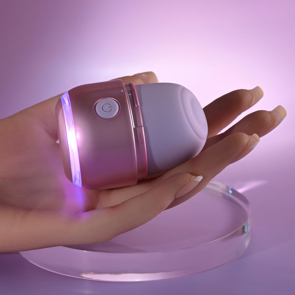 Hand holding a USB rechargeable tapping stimulator with colorful light effects.