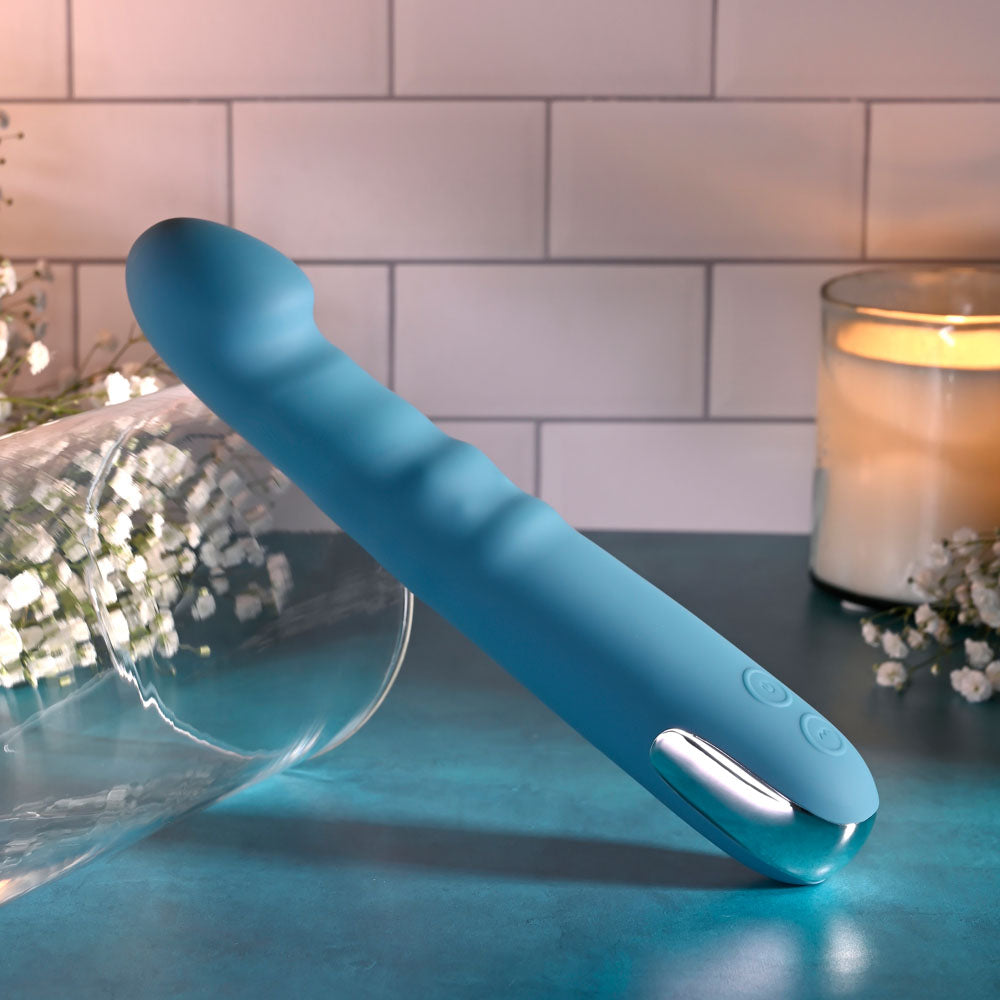 Evolved QUEEN OF ALL TRADES - 22.6 cm USB Rechargeable Thrusting & Rotating Vibrator on a blue surface.