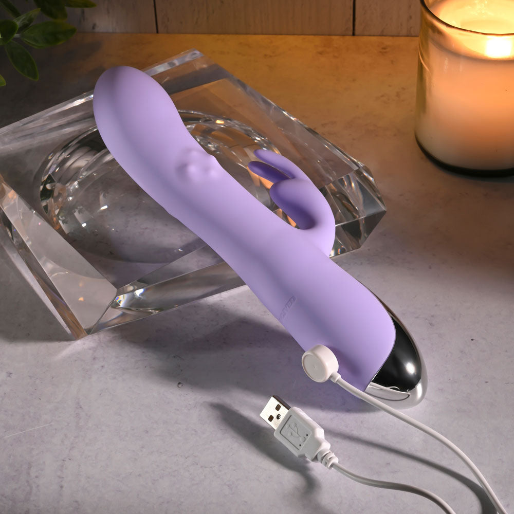 Evolved SPINDERELLA -  USB Rechargeable Rabbit Vibrator charging next to a candle, showcasing its sleek design and functionality.