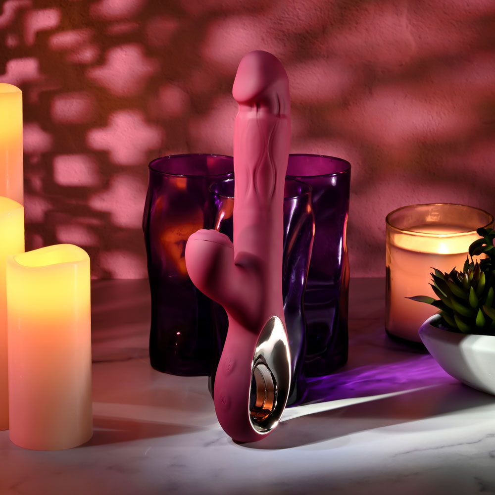 Evolved BURSTING WITH PLEASURE - 25.4 cm USB Rechargeable Vibrator with Tapping Clitoral Stimulator on a table with candles.