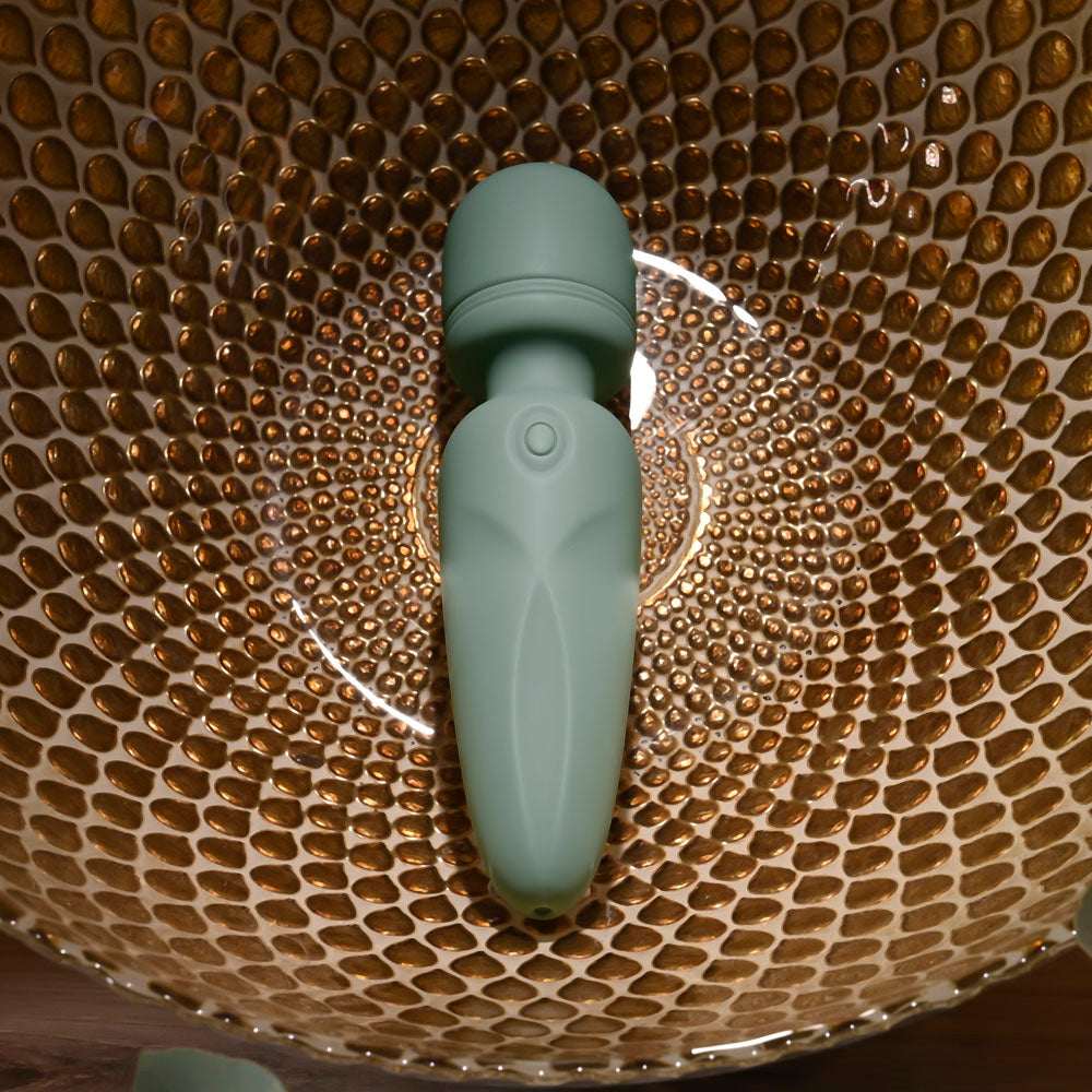 Evolved RUMBLE WAND - Olive 13.4 USB Rechargeable Mini Massage Wand placed in a decorative bowl.