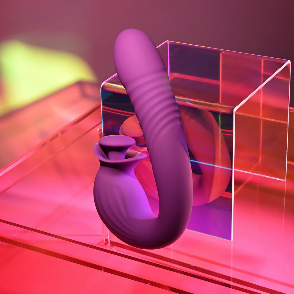 Evolved DEEP ECSTASY - 16.5 cm USB Rechargeable Thrusting and Tapping Vibrator on display in vibrant pink lighting.