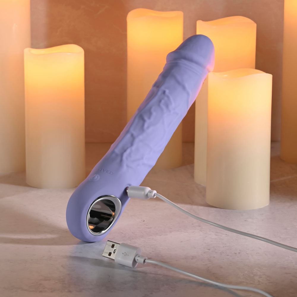 Evolved LARGE FANTASY - 21.8 cm USB Rechargeable Vibrator next to glowing candles, ideal for intimate essentials for her.