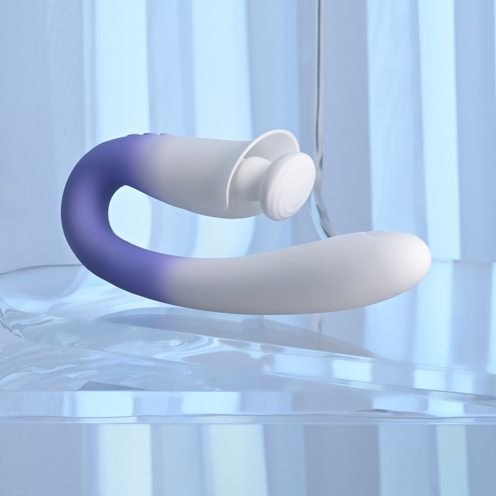 Evolved SPRING LOADED - /Purple 23 cm USB Rechargeable Multi-Tapping Vibrator on a reflective surface.