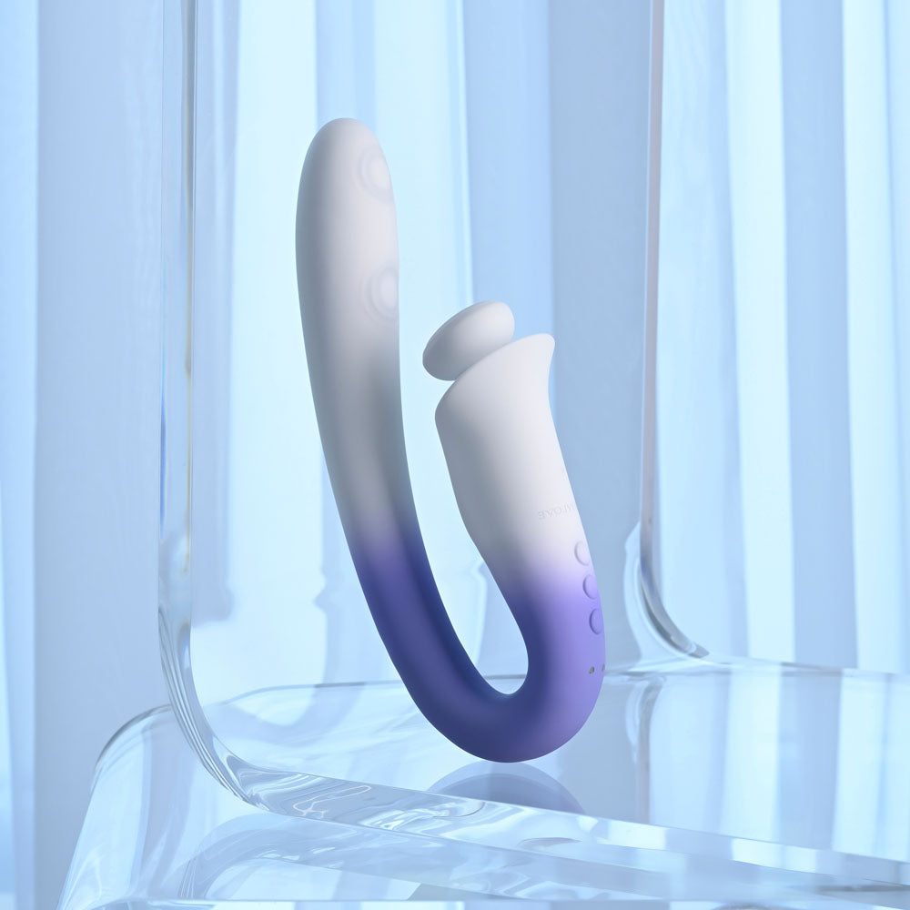 Evolved SPRING LOADED - /Purple 23 cm USB Rechargeable Multi-Tapping Vibrator on a clear surface in soft lighting.