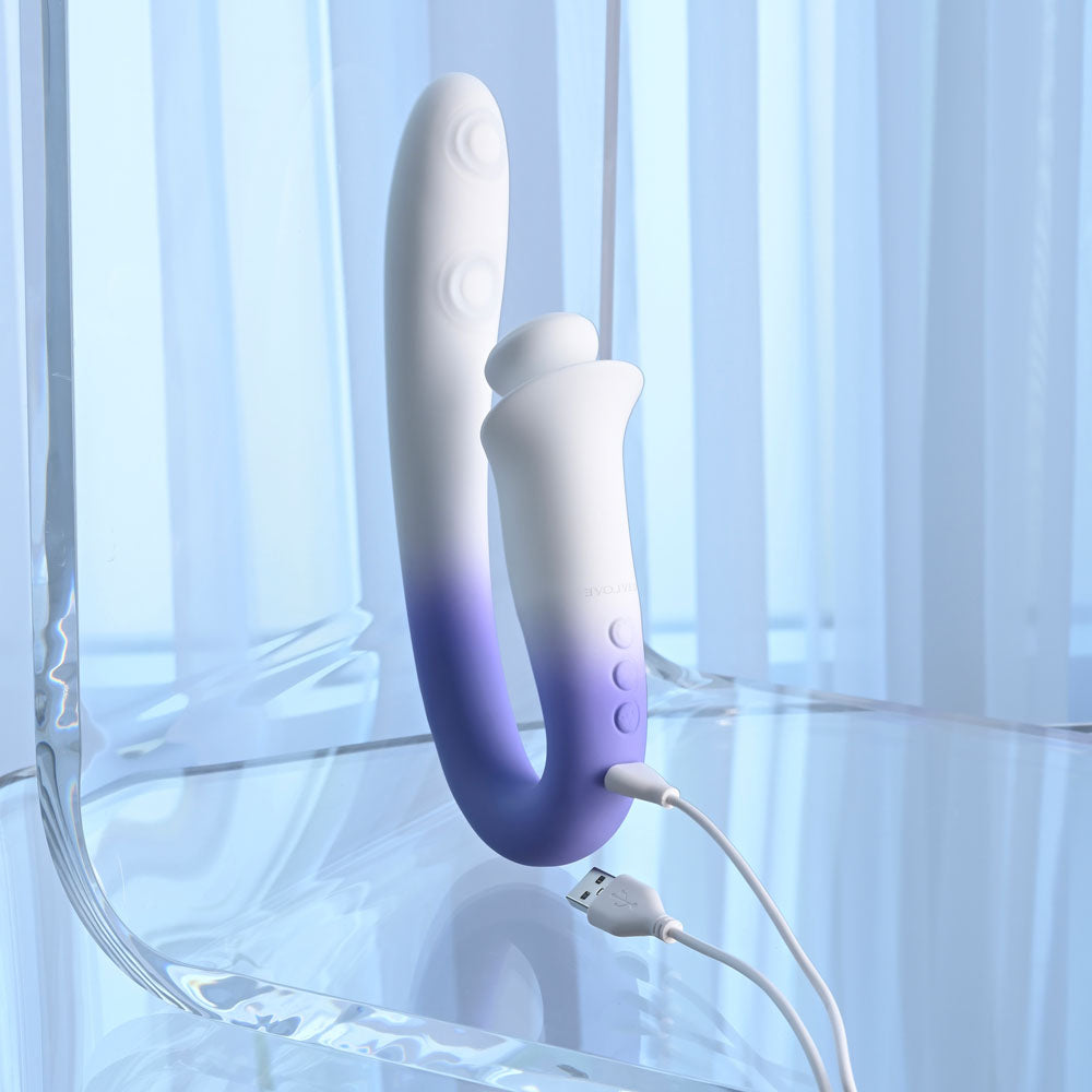 Evolved SPRING LOADED - /Purple 23 cm USB Rechargeable Multi-Tapping Vibrator on a clear surface with charging cable.