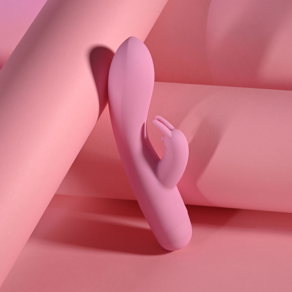 Evolved CUSHY BUNNY - 19.1 cm USB Rechargeable Rabbit Vibrator on a pink background, showcasing its soft design and bunny stimulator.