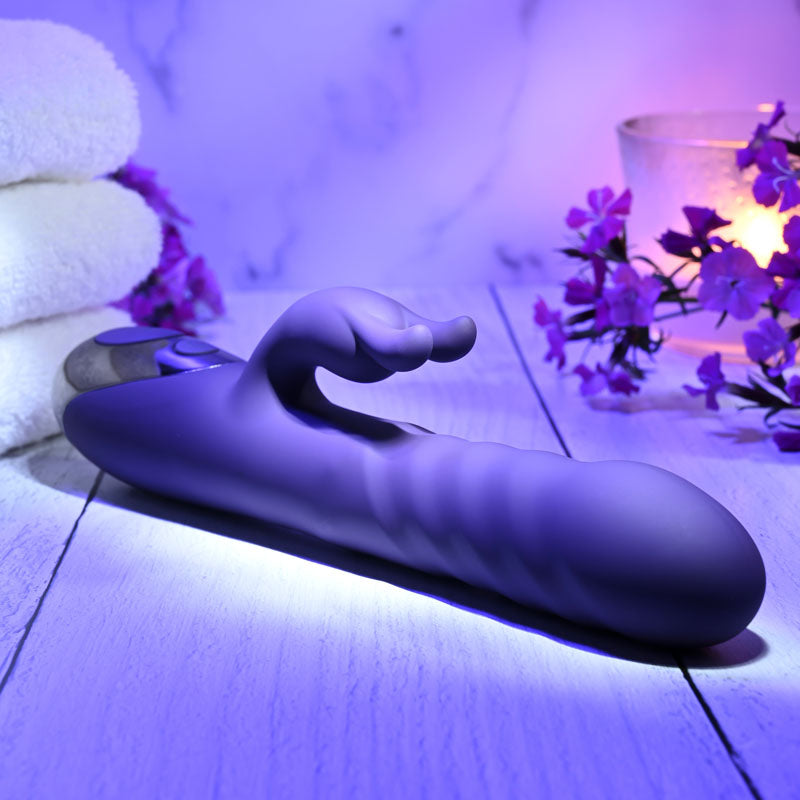 Evolved RASCALLY RABBIT - 22.9 cm USB Rechargeable Rabbit Vibrator on wooden surface with towels and flowers.