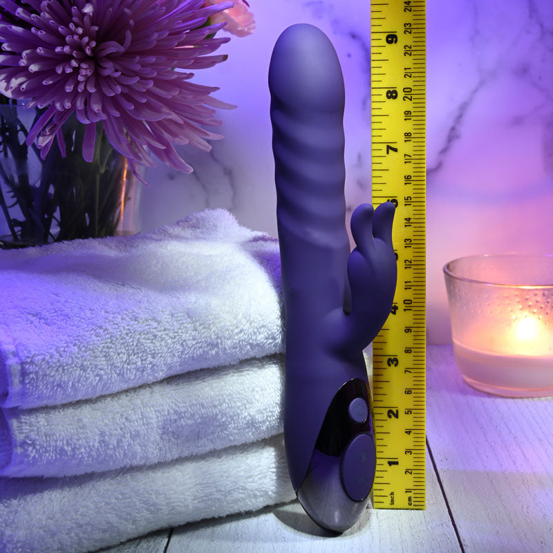 Evolved RASCALLY RABBIT - 22.9 cm USB Rechargeable Rabbit Vibrator next to measuring tape and towels.