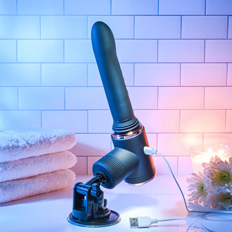 Evolved TOO HOT TO HANDLE -  USB Rechargeable Thrusting Vibe with Stand on a counter with towels and candles.
