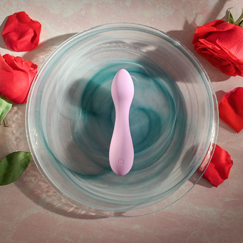 Evolved LILAC G - Lilac 11.5 cm USB Rechargeable Mini Vibrator surrounded by roses in a glass bowl.