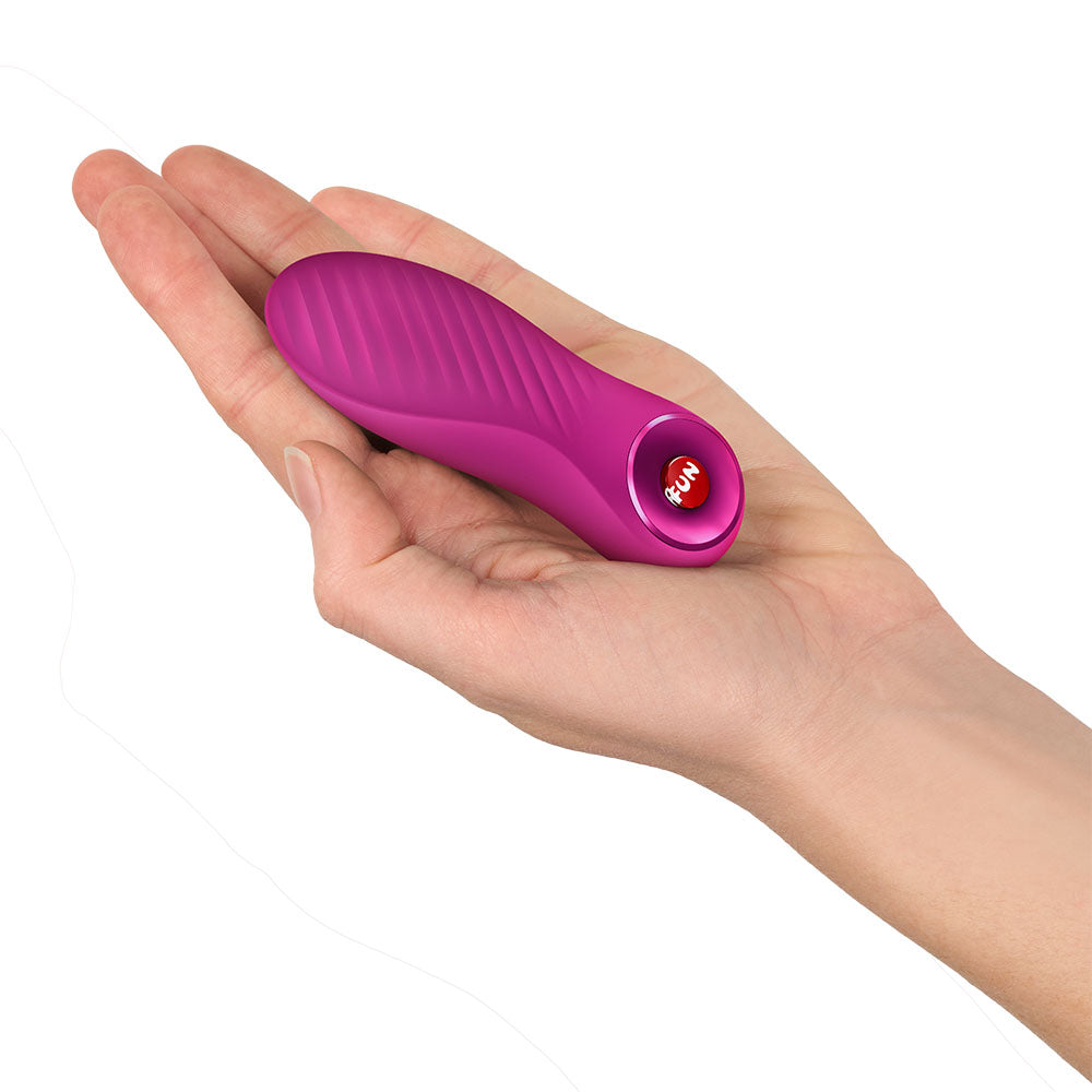 Fun Factory BIJOU Magenta - Magenta USB-C Rechargeable Stimulator held in a hand, showcasing its compact design.