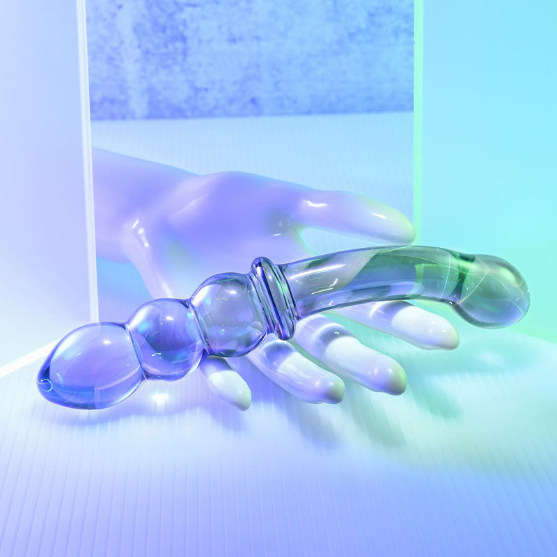 Gender X LUSTROUS GALAXY WAND – Violet Glass 18.5 cm Double Ended Massager on a hand with soft lighting.