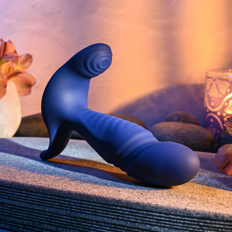 Gender X TRUE -  13.5 cm USB Rechargeable Thrusting Prostate Massager in blue silicone on a textured surface.