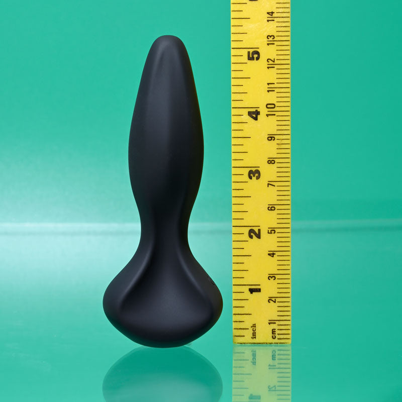 Gender X HIP TO BE SQUARE - silicone vibrating toy beside a ruler for size reference on a green background.