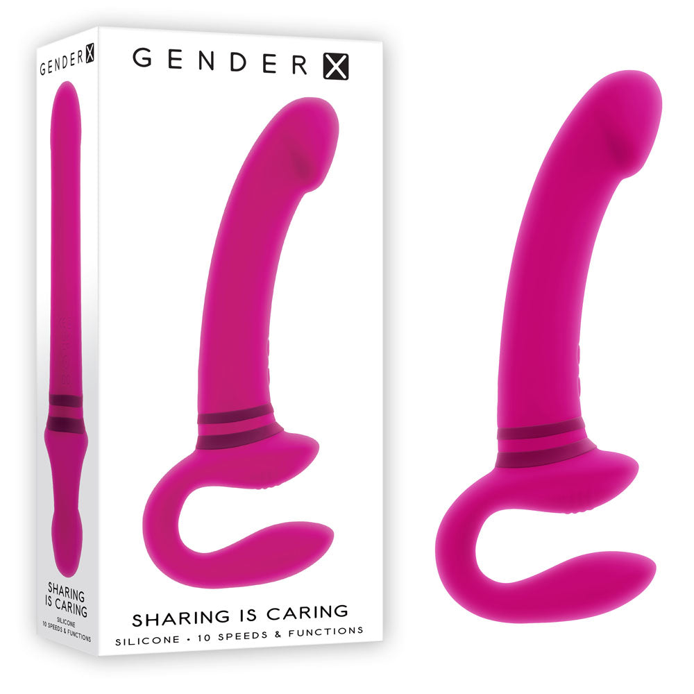 Gender X SHARING IS CARING rechargeable strap-on vibrator in vibrant pink, showcasing the unique design and dual-motor features.