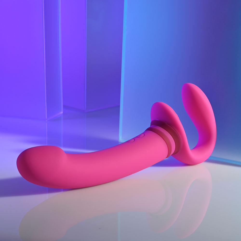Gender X rechargeable strap-on vibrator featuring dual motors and a flexible design in a vibrant pink color.