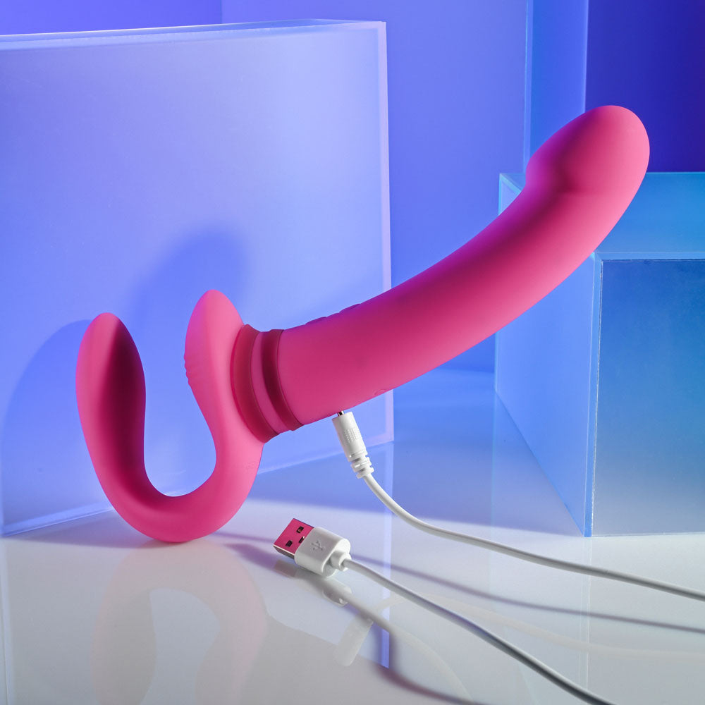 Gender X SHARING IS CARING - 21.9 cm USB Rechargeable Strapless Strap-On in pink with USB charging cable.