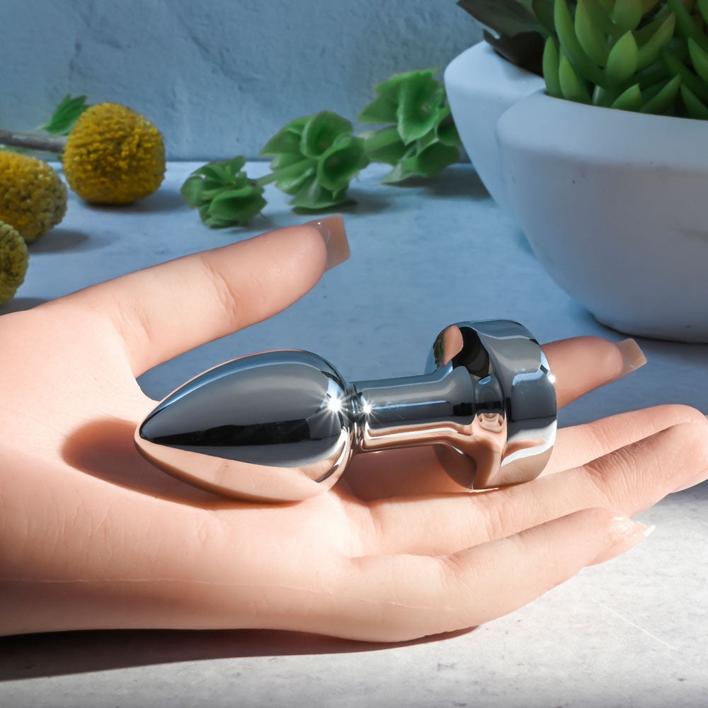 Gender X ROCKIN METAL PLUG MINI -  7.8 cm USB Rechargeable Vibrating Mini Butt Plug in a hand, showcasing its sleek design.