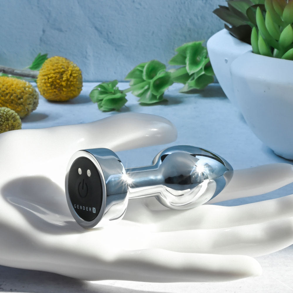 Gender X ROCKIN METAL PLUG MINI -  7.8 cm USB Rechargeable Vibrating Mini Butt Plug on a hand with decorative elements.