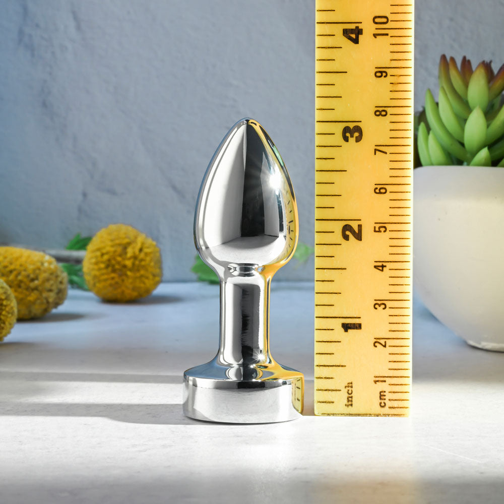 Gender X ROCKIN METAL PLUG MINI -  7.8 cm USB Rechargeable Vibrating Mini Butt Plug next to a ruler for size reference.