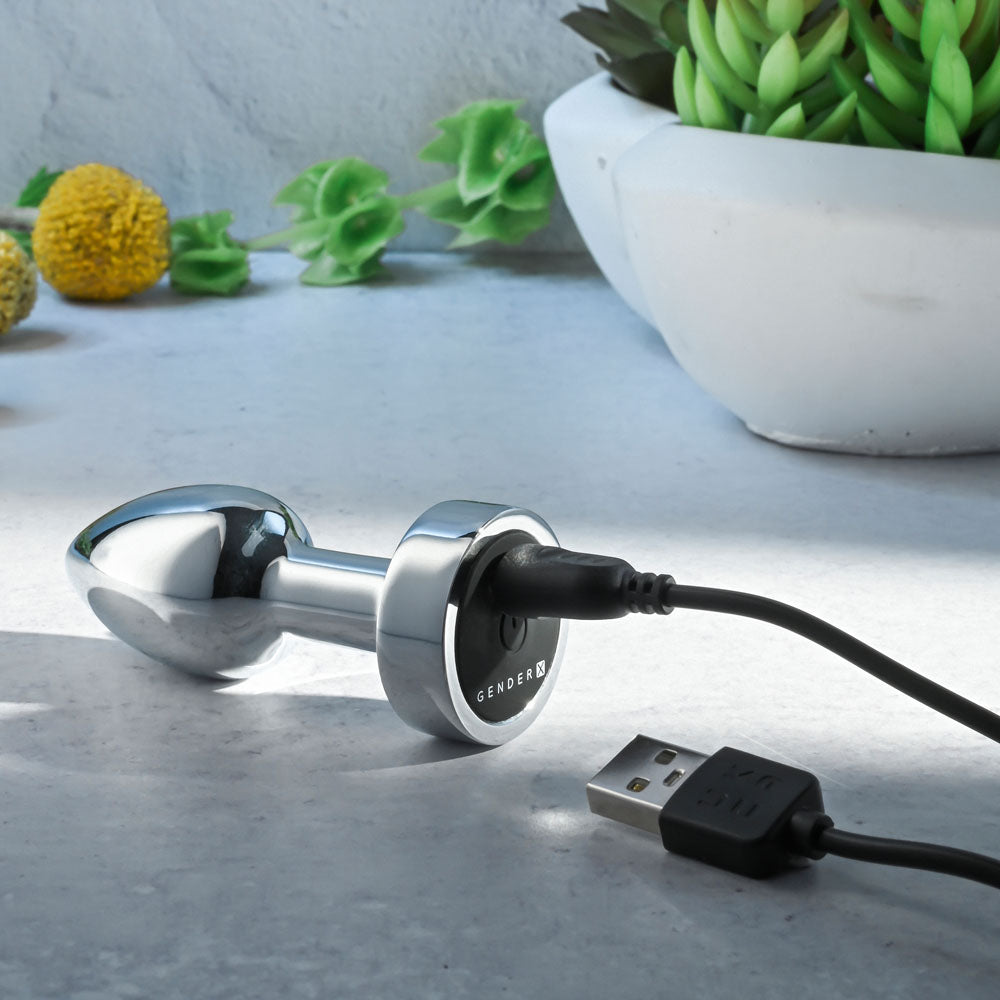 Gender X ROCKIN METAL PLUG MINI -  7.8 cm USB Rechargeable Vibrating Mini Butt Plug charging on a marble surface.