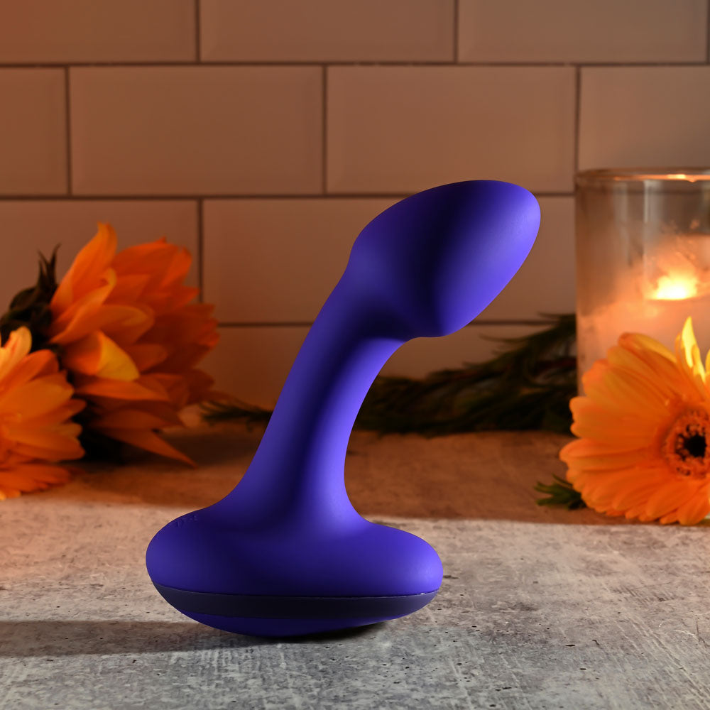 Gender X ANYBODYS PLUG - 11.4 cm USB Rechargeable Vibrating Butt Plug in purple with flowers and candles in the background.