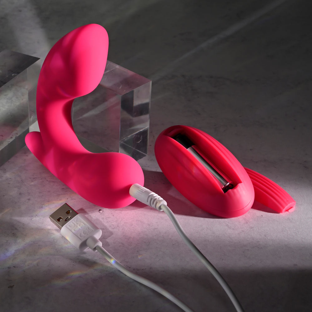 Gender X ALL ABOUT THE BASS -  USB Rechargeable Wearable Vibrator with Wireless Remote displayed in pink with charging cable.