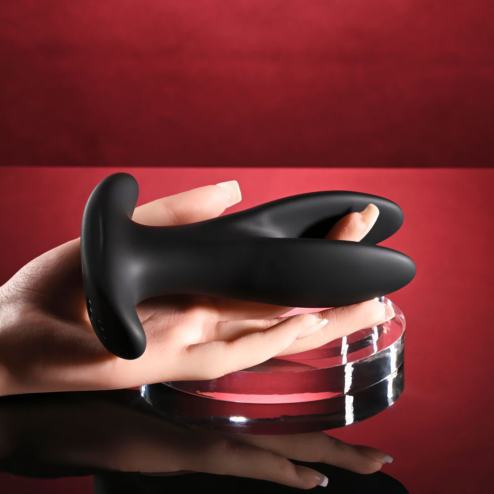 Gender X SPREAD THE LOVE -  USB Rechargeable Stretching Anal Plug with Wireless Remote on display with a hand.
