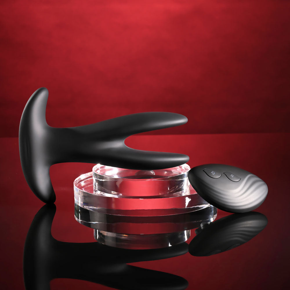 Gender X SPREAD THE LOVE - USB Rechargeable Stretching Anal Plug with Wireless Remote placed on a glossy surface.