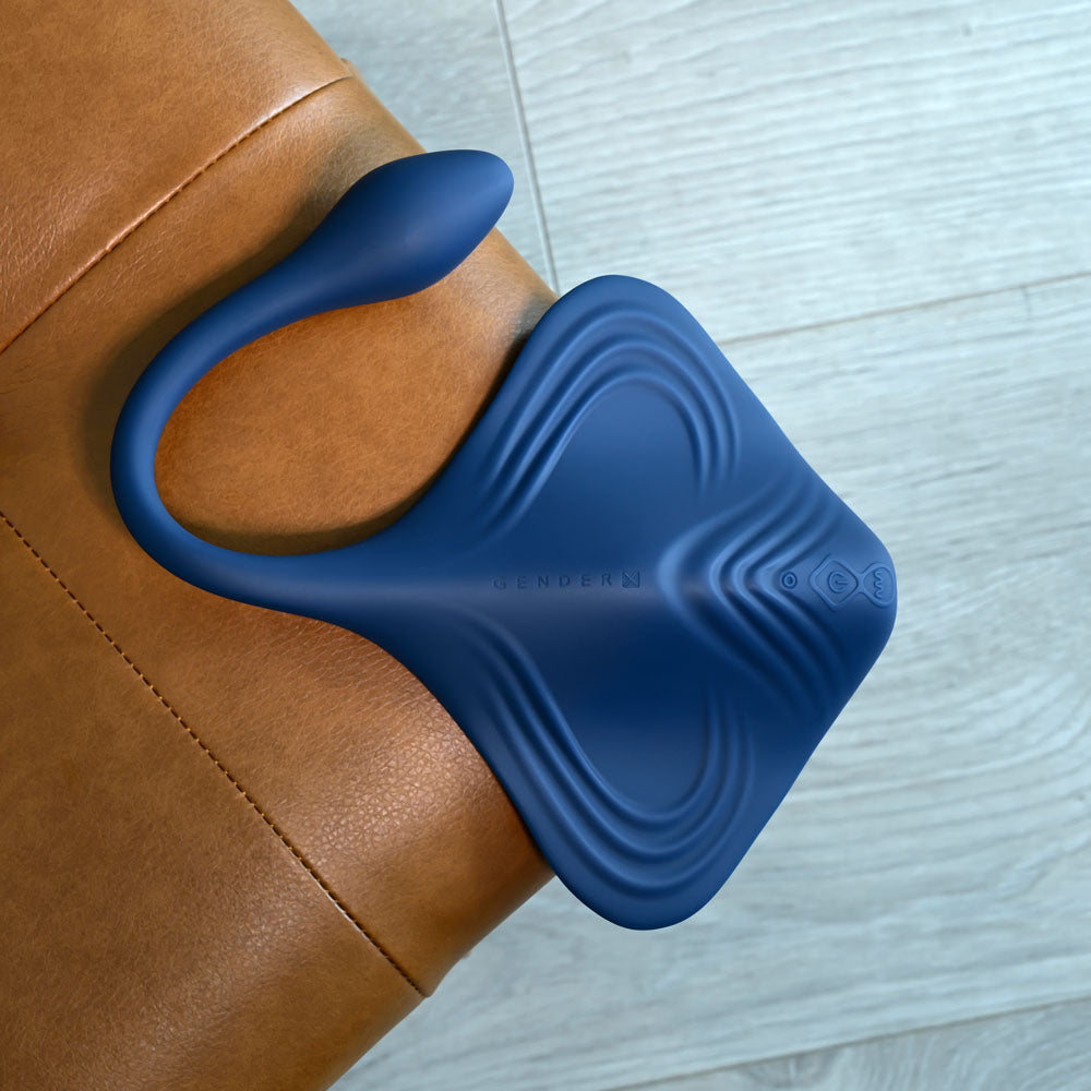 Gender X DAILY GRIND -  USB Rechargeable Grinding Pad with Anal Plug on a brown leather surface.