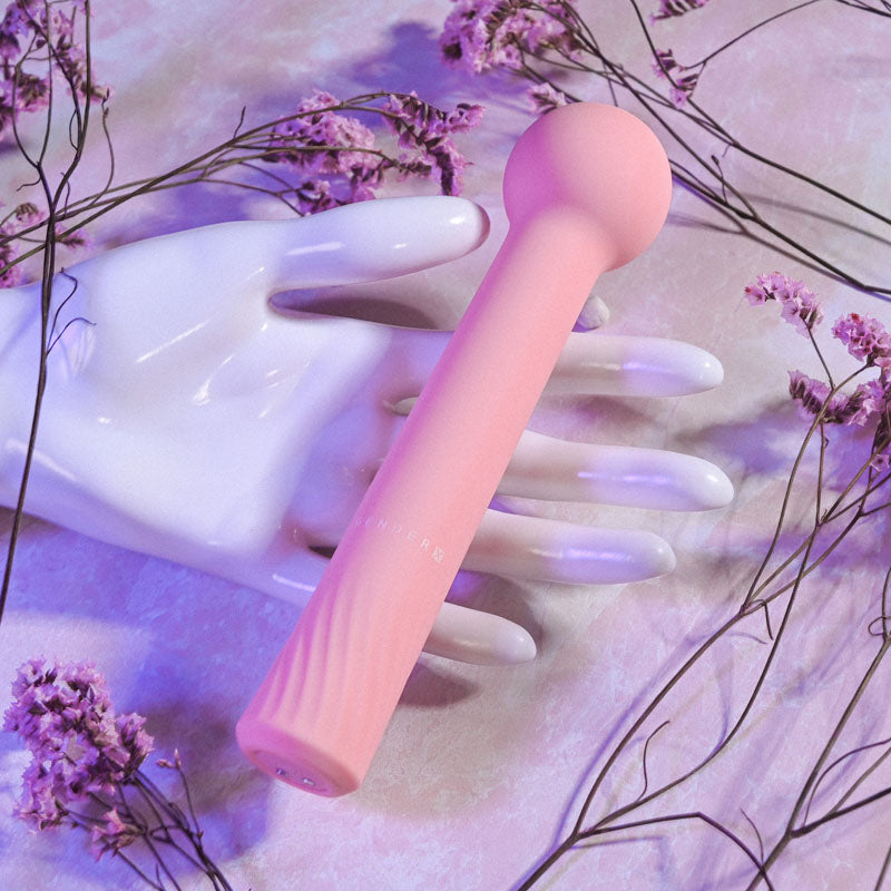 Gender X FLEXI WAND -  16.6 cm USB Rechargeable Vibrator resting on a white hand with dried flowers.