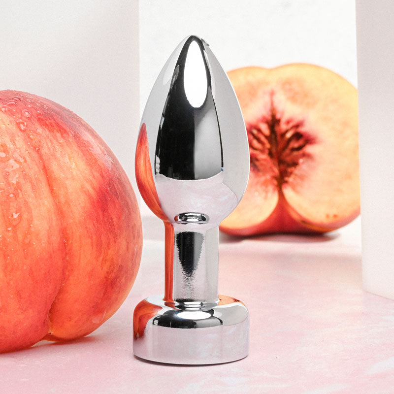 Gender X ROCKIN' METAL PLUG - Metallic 9.3 cm USB Rechargeable Butt Plug with fruit in the background.