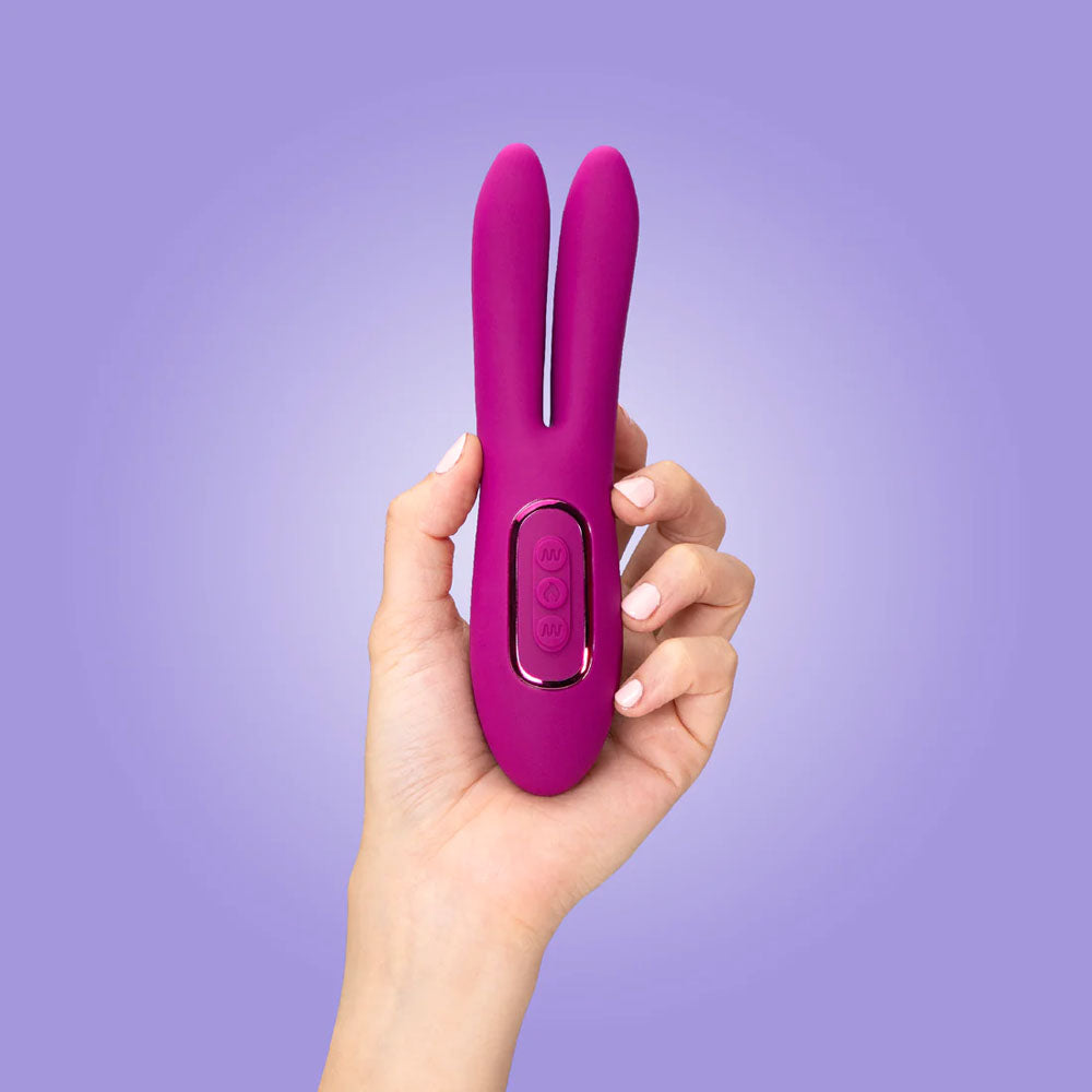 JimmyJane Solis Ascend 2 PRO -  16 cm USB Rechargeable Dual Tip Stimulator held in hand against a purple background.