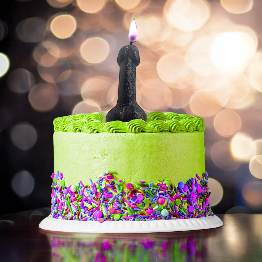A vibrant birthday cake with green frosting topped with a Glitterati Glitter Penis Candle - 10 cm Penis Party Candle.