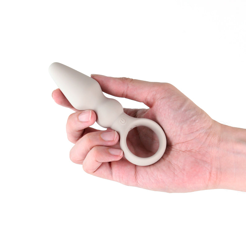 Hand holding Lust-n-Dreams Bossa Fog 12.5 cm rechargeable vibrating butt plug for enhanced pleasure.