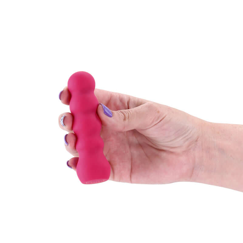 Hand holding a pink X & O's Embrace 9.9 cm USB rechargeable bullet vibrator made from premium silicone.