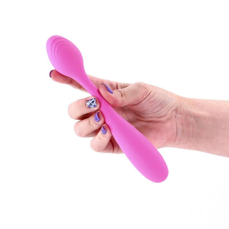Hand holding a pink silicone USB rechargeable vibrator for versatile pleasure.