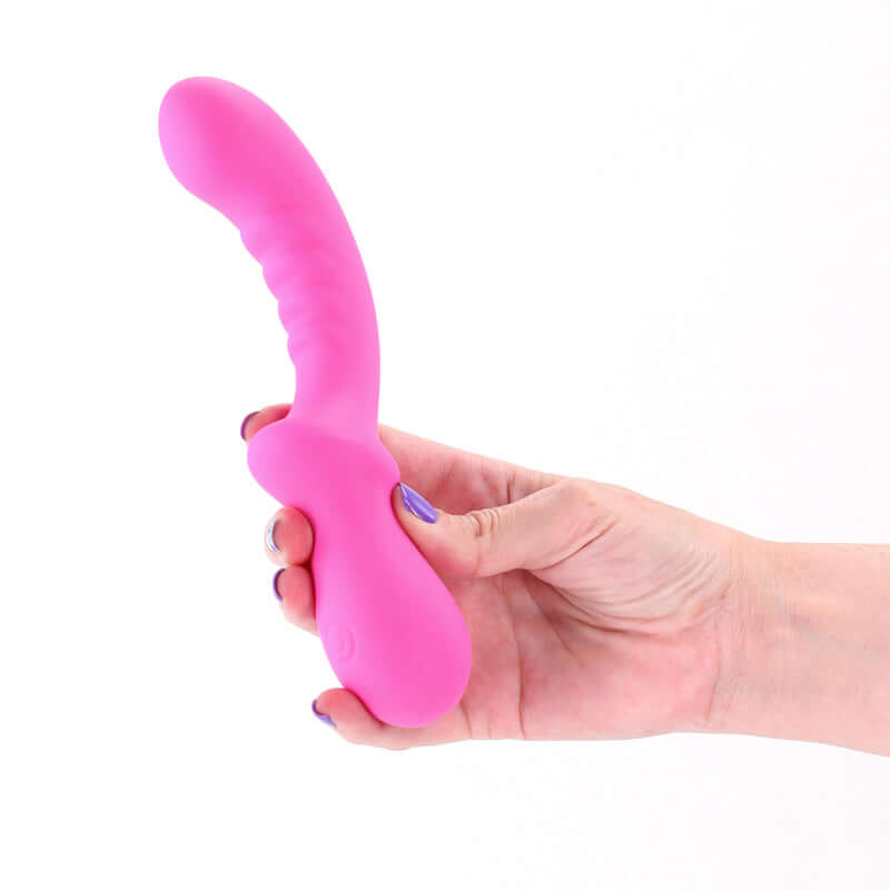 Pretty in Peony - 19.8 cm USB rechargeable G-spot vibrator in a hand, showcasing its pink silicone design.