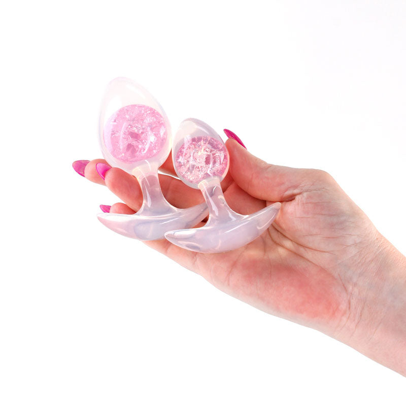 Glams Cosmic 2pc Kit -  - Clear/ Butt Plugs - Set of 2 Sizes held in hand, featuring vibrant internal glass marbles.