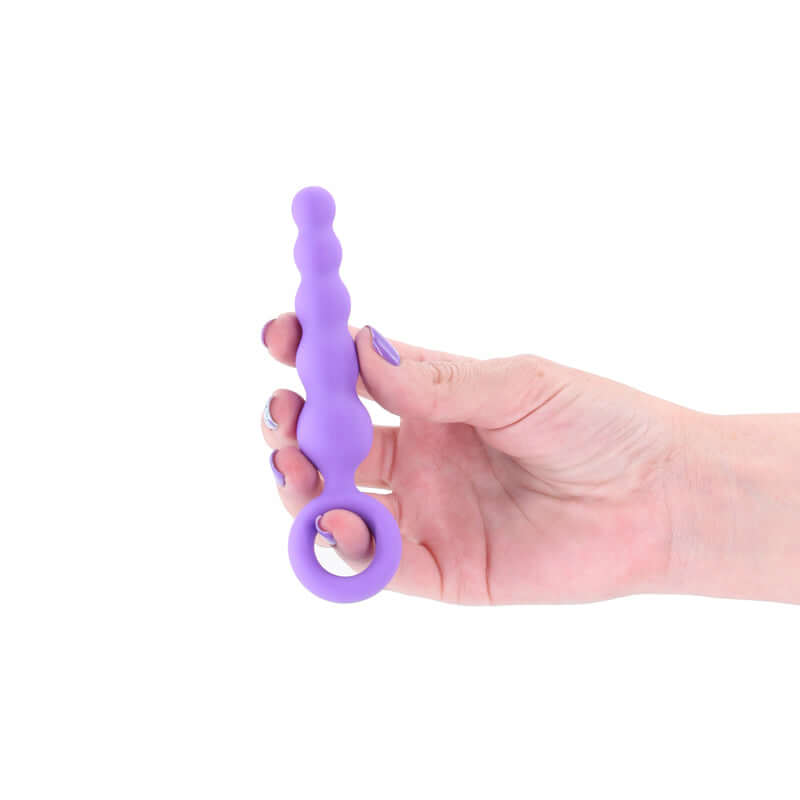Beginner anal plug 12.7 cm in a hand, featuring a tapered and slim design with finger rings for comfort.