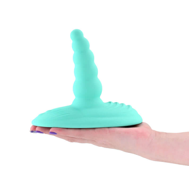 Aqua USB rechargeable vibrating grinder pad held in hand, showcasing its design and silicone texture for pleasure.