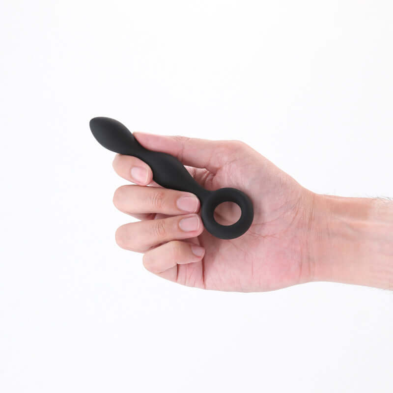 Hand holding Renegade Slim 12.7 cm anal plug, a beginner anal plug in plush silicone for comfort and control.