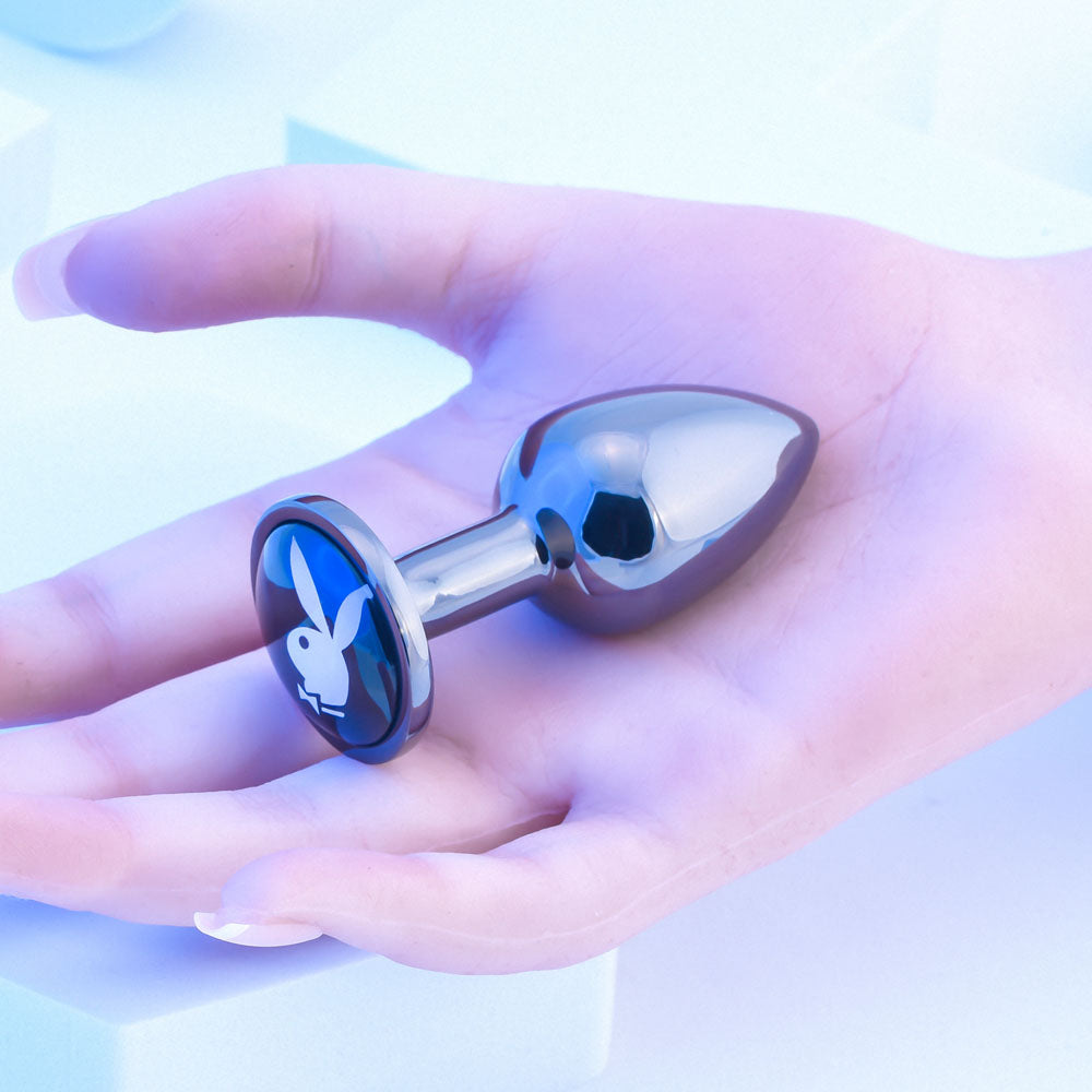 Playboy Pleasure TUX - Small - Metal 7.4 cm Small Butt Plug in a hand, showcasing sleek design and flared base.