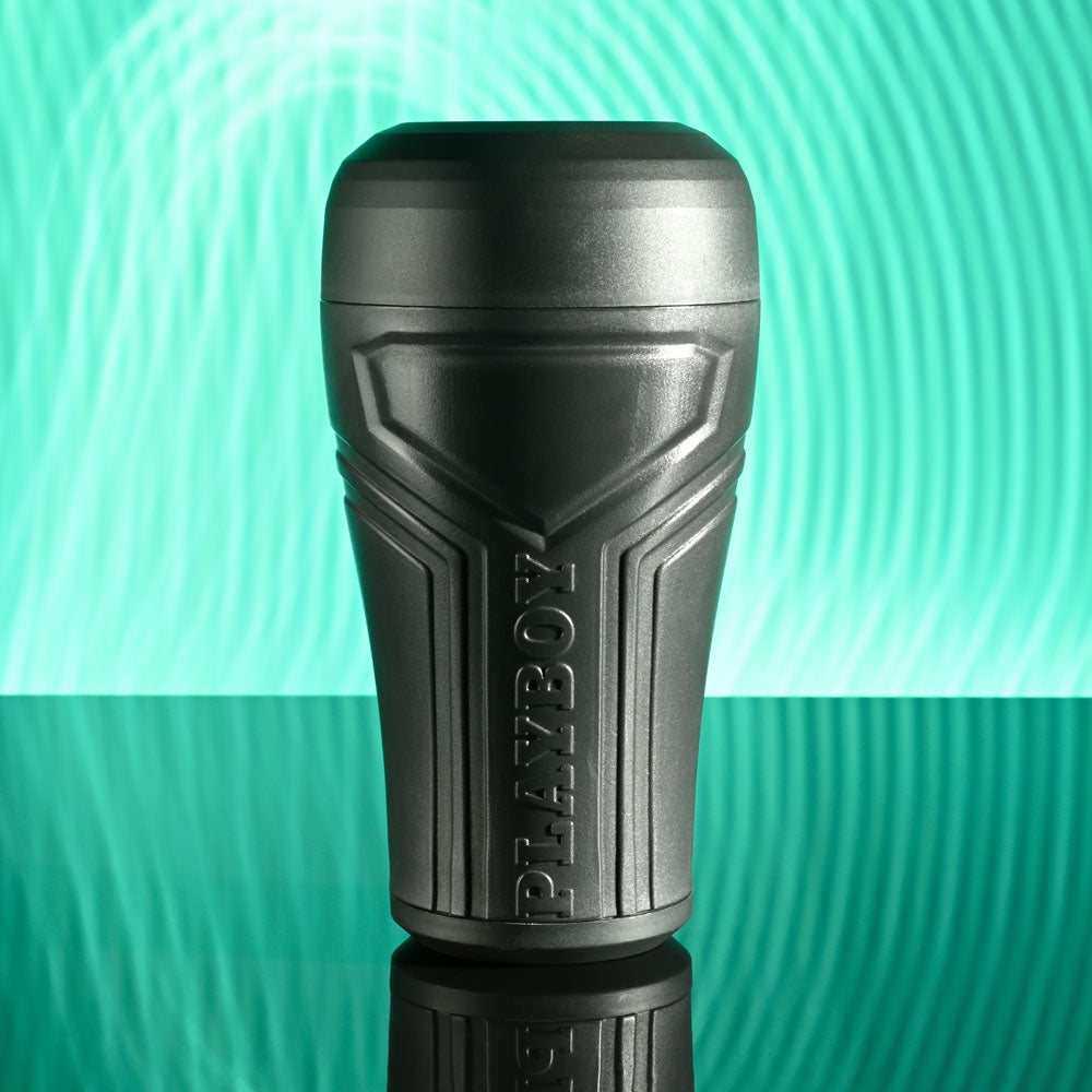 Playboy Pleasure THE URGE SMALL - Clear Small Stroker on reflective surface with vibrant background.