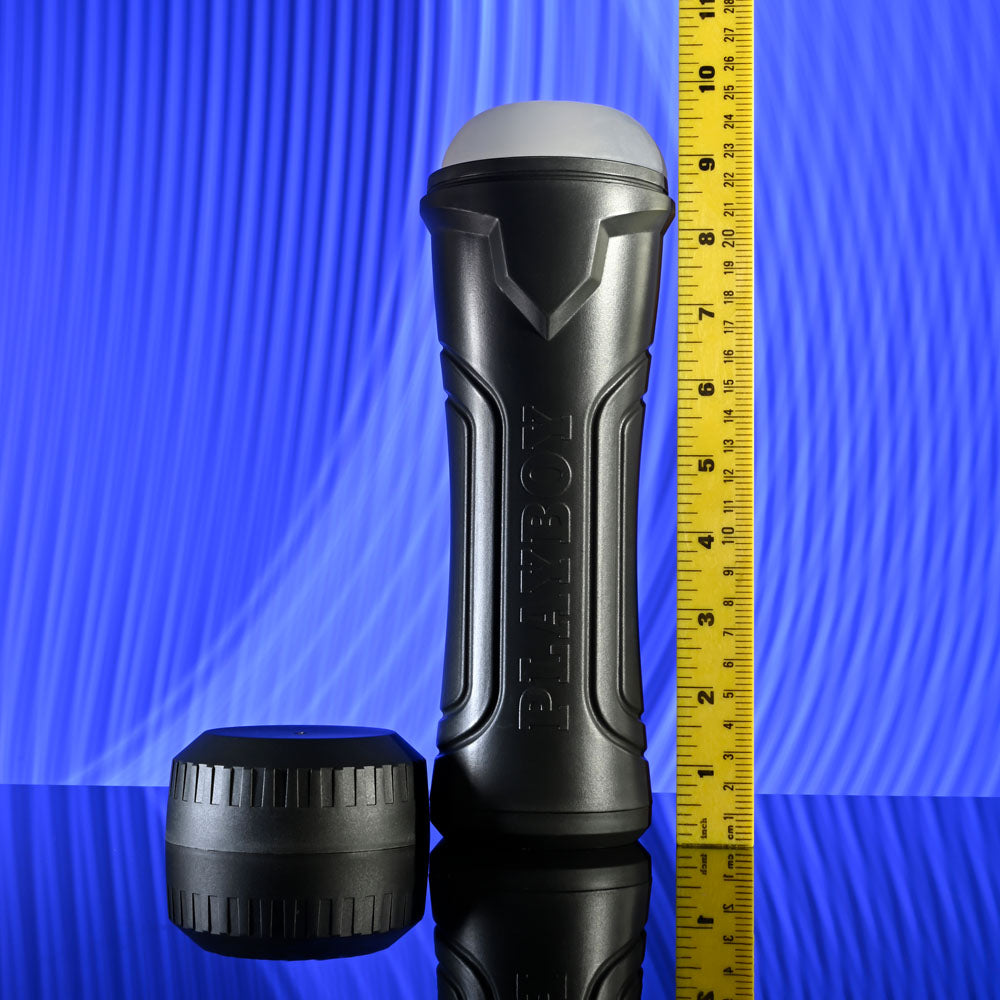 Playboy Pleasure THE URGE LARGE - Clear Stroker on a reflective surface with a measuring tape for size reference.