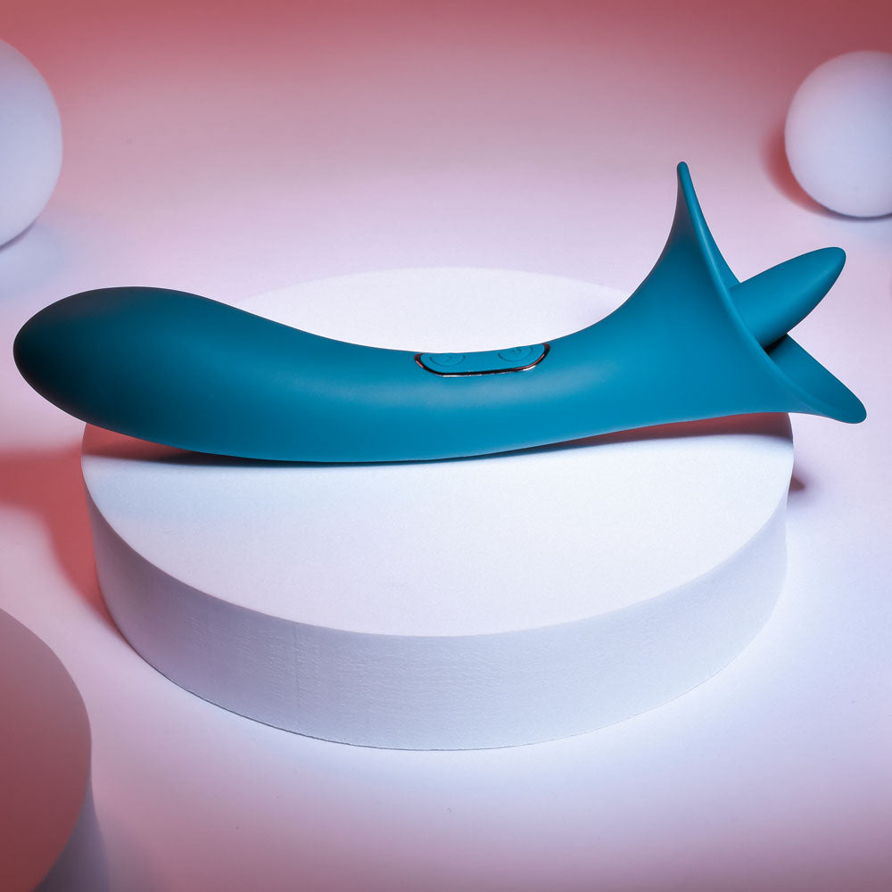 Playboy Pleasure TRUE INDULGENCE - Teal 21.3 cm USB Rechargeable Vibrator with Flicking Tip on display.