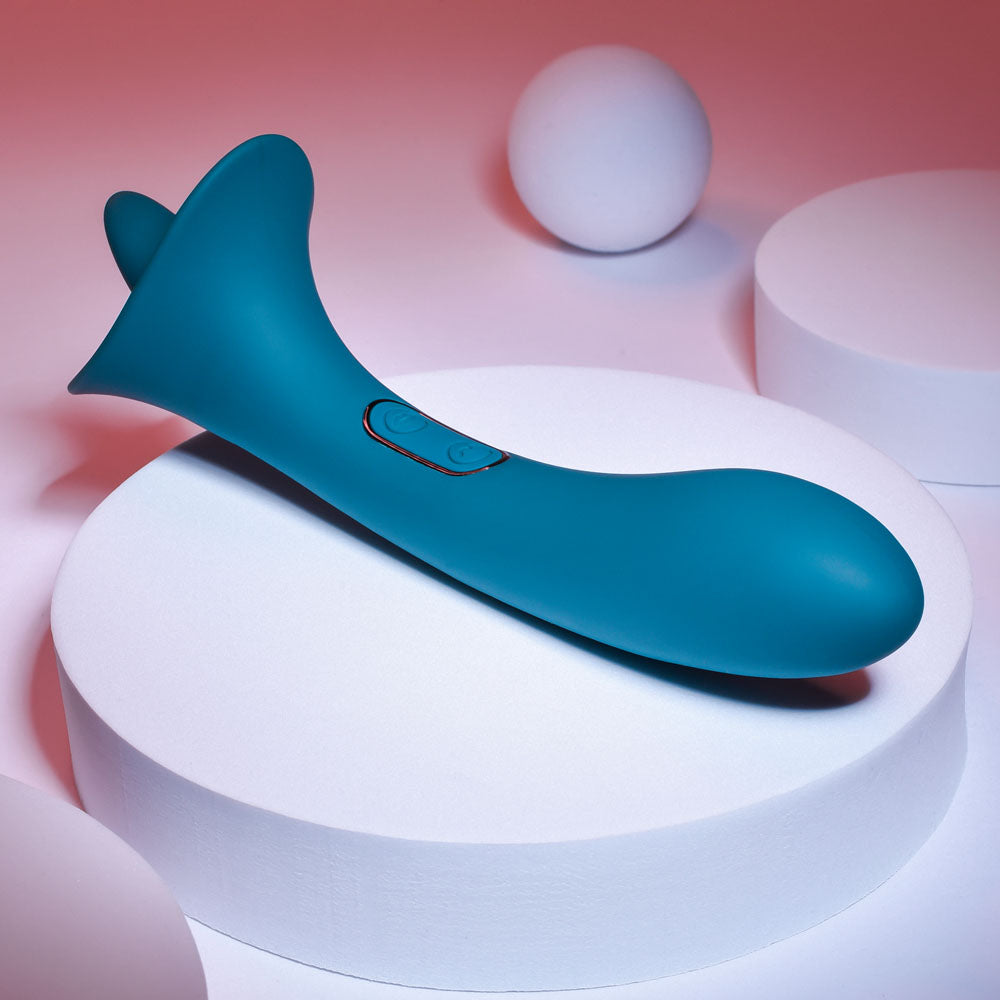 Playboy Pleasure TRUE INDULGENCE - Teal 21.3 cm USB Rechargeable Vibrator with Flicking Tip on display.