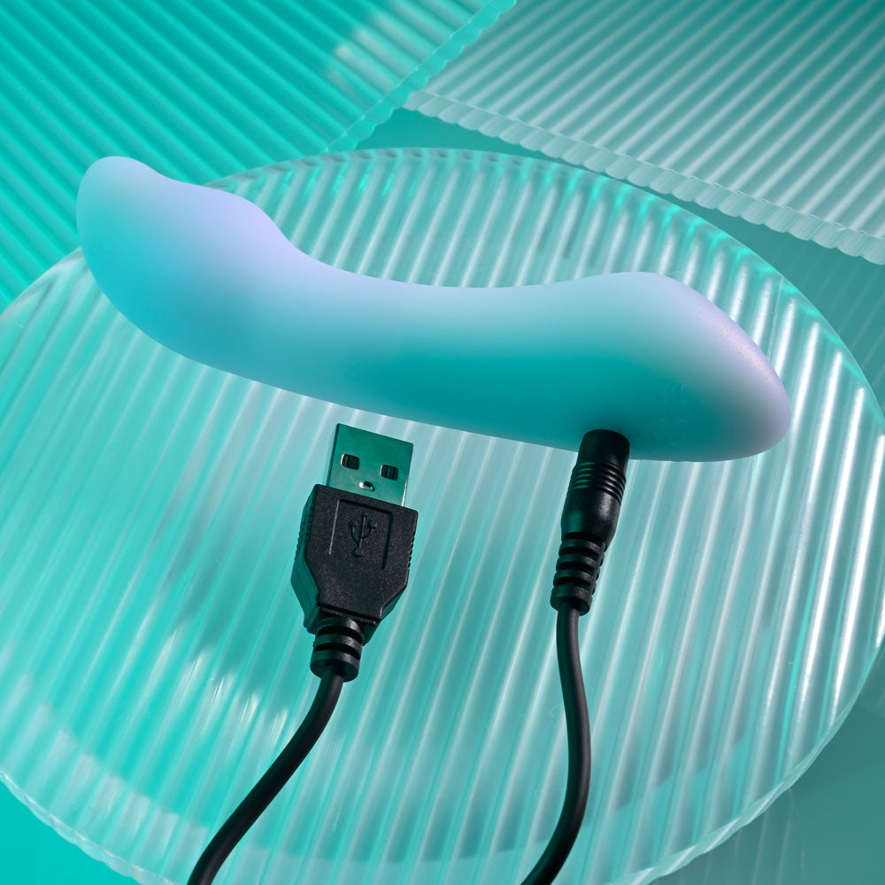 Playboy Pleasure EUPHORIA - Opal 12 cm USB Rechargeable Mini Vibrator on a plate with USB charging cable.