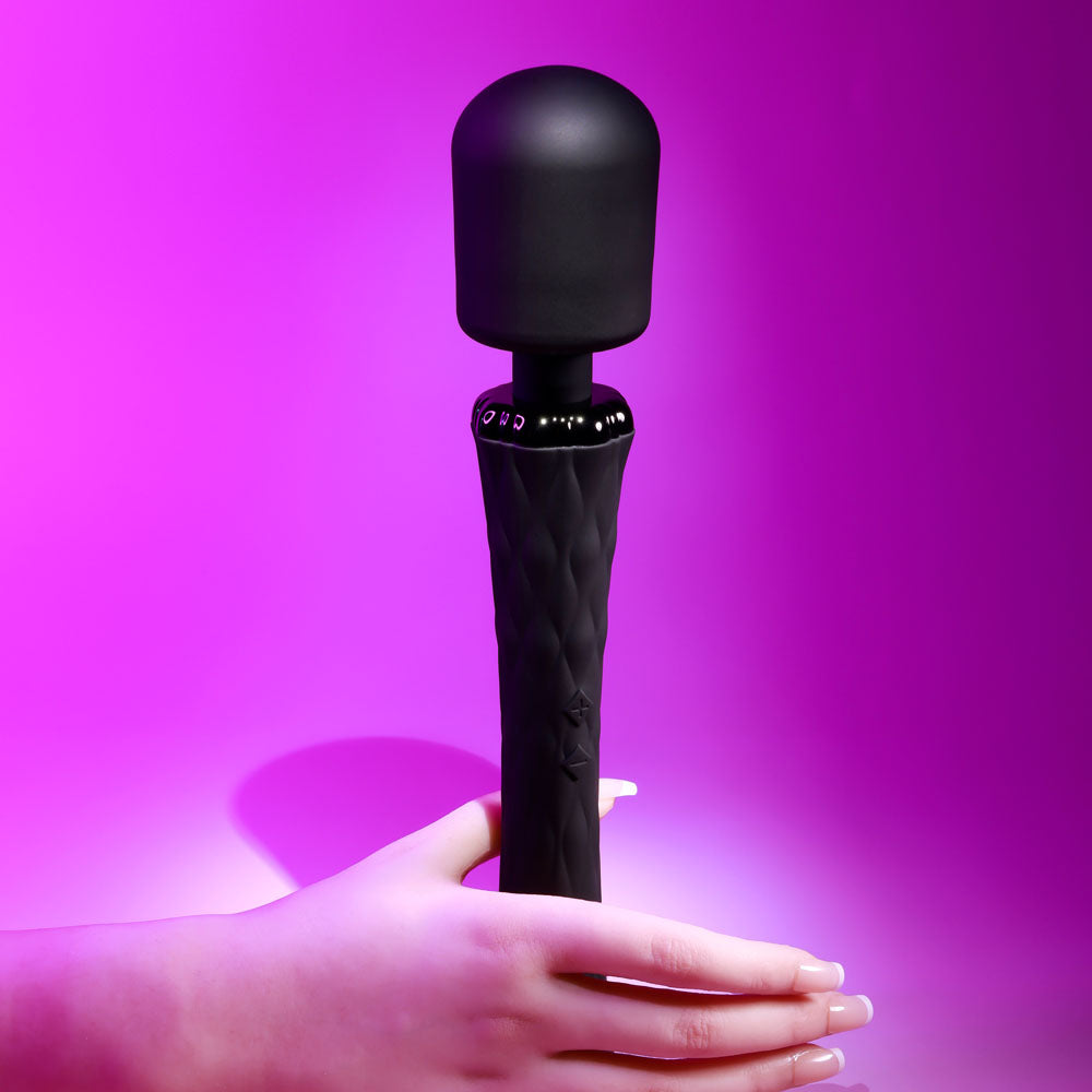 Playboy Pleasure ROYAL - 29.2 cm USB Rechargeable Massage Wand in hand against a vibrant purple background.